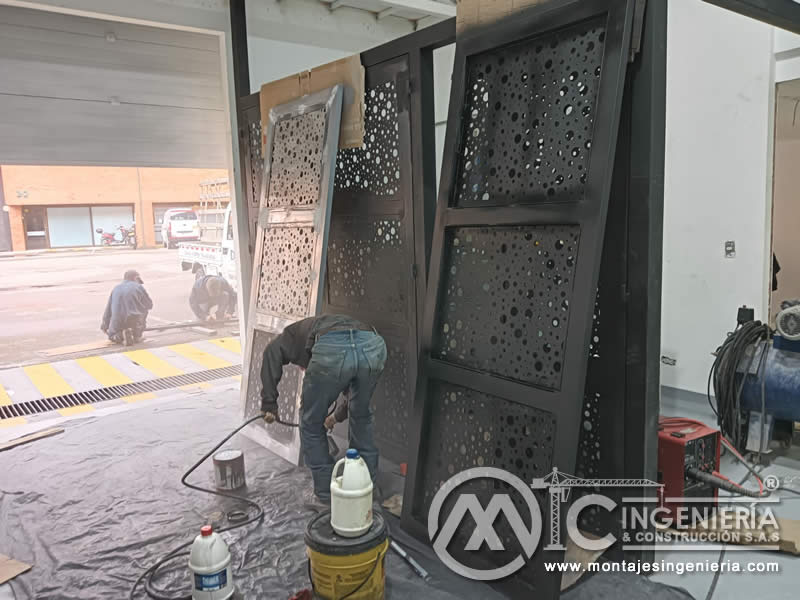 Pintura de paneles metálicos calados con pistola de aspersión para proyectos de adecuación en Bogotá, Colombia. Montajes, Ingeniería y Construcción MIC SAS.