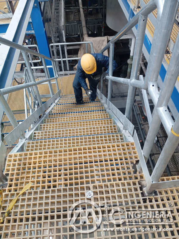 Piso de rejilla plástica en plataforma industrial con barandas tubulares galvanizadas en Bogotá, Colombia. Montajes, Ingeniería y Construcción MIC SAS.
