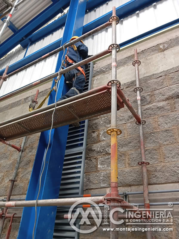 Trabajo en altura con arnés de seguridad para montaje de equipos industriales sobre andamios en Bogotá, Colombia. Montajes, Ingeniería y Construcción MIC SAS.