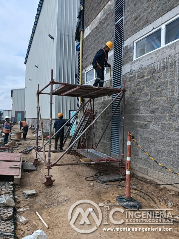 Anclaje y sellado de rejillas metálicas en fachadas industriales con andamio en Bogotá, Colombia. Montajes, Ingeniería y Construcción MIC SAS.
