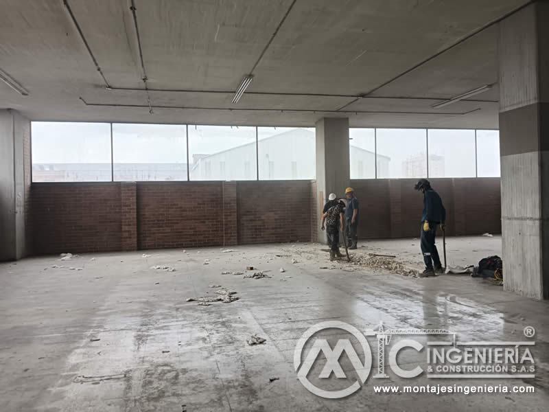 Inicio de demolición de enchape en parqueadero de edificio comercial para adecuación en Bogotá, Colombia. Montajes, Ingeniería y Construcción MIC SAS.