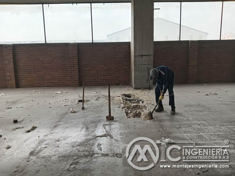 Limpieza y apertura de fosa puntual en piso de parqueadero para intervención estructural en Bogotá, Colombia. Montajes, Ingeniería y Construcción MIC SAS.