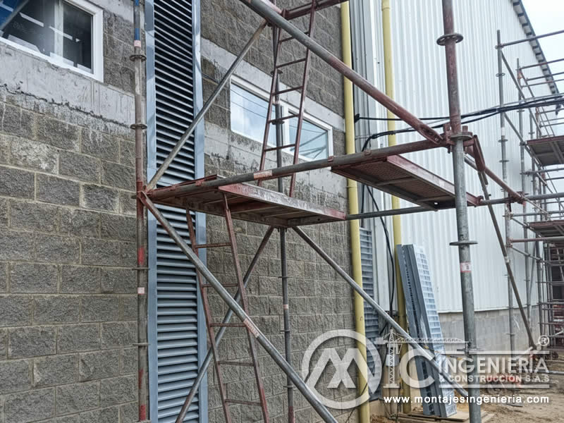 Montaje de rejillas de ventilación en fachada con andamio en plantas industriales en Bogotá, Colombia. Montajes, Ingeniería y Construcción MIC SAS.