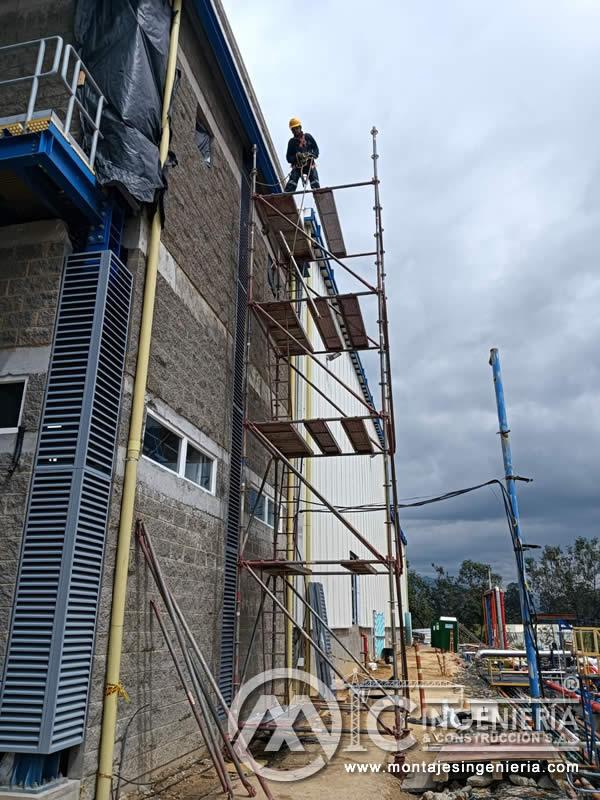 Montaje de rejillas en fachadas de plantas industriales en altura con andamio en Bogotá, Colombia. Montajes, Ingeniería y Construcción MIC SAS.