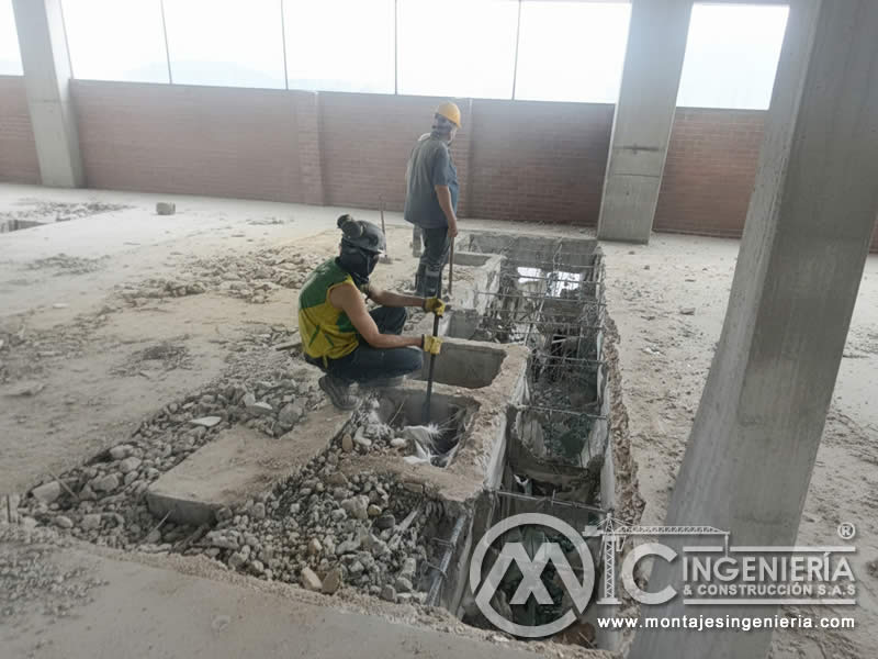 Operarios en demolición de viga de cimentación con recuperación de acero de refuerzo en Bogotá, Colombia. Montajes, Ingeniería y Construcción MIC SAS.
