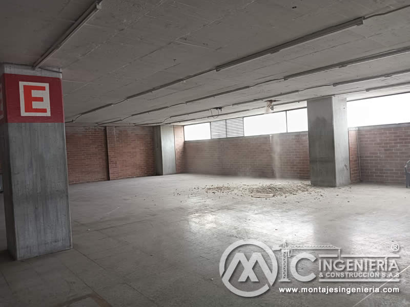 Parqueadero cubierto tras retiro de enchape listo para nuevos acabados en Bogotá, Colombia. Montajes, Ingeniería y Construcción MIC SAS.