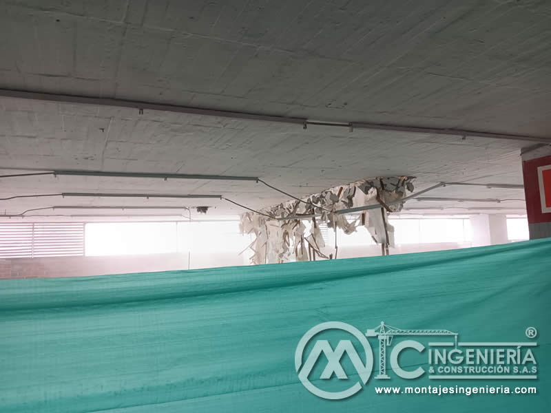 Protección con plástico en demolición de cielo raso de parqueadero cubierto en Bogotá, Colombia. Montajes, Ingeniería y Construcción MIC SAS.