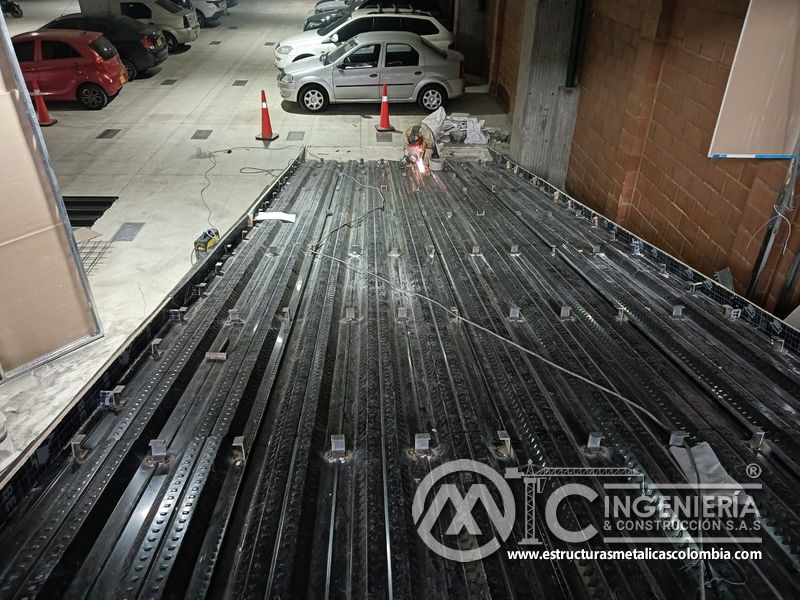 Soporte metálico bajo rampas de concreto en parqueadero acceso edificio en Bogotá, Colombia. Montajes, Ingeniería y Construcción MIC SAS.