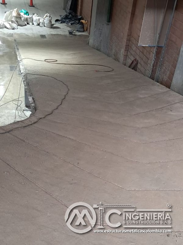 Soporte metálico bajo rampas de concreto en parqueadero comercial en Bogotá, Colombia. Montajes, Ingeniería y Construcción MIC SAS.