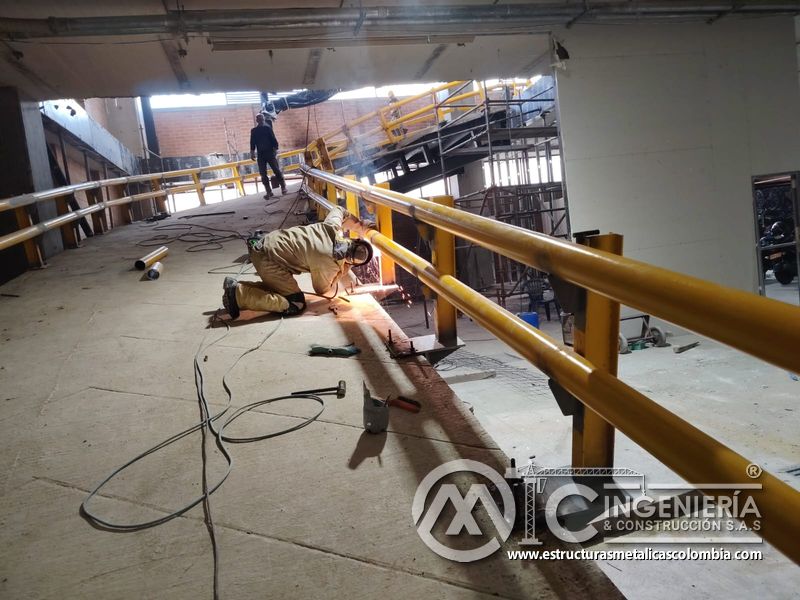 Soldadura y pintura de barandas para rampas vehiculares concreto acceso en Bogotá, Colombia. Montajes, Ingeniería y Construcción MIC SAS.