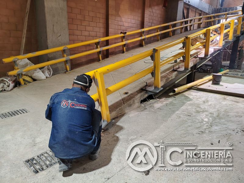 Soldadura y pintura de barandas para rampas vehiculares parqueadero en Bogotá, Colombia. Montajes, Ingeniería y Construcción MIC SAS.