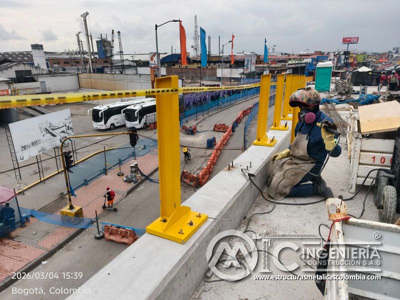 Trabajador fijando base de poste amarillo sobre pretil del puente Venecia con fabricación e instalación profesional en Bogotá, Colombia. Montajes, Ingeniería y Construcción. MIC SAS. Trabajador fijando base de poste amarillo sobre pretil del puente Venecia en Bogotá, Colombia. Montajes, Ingeniería y Construcción. MIC SAS.