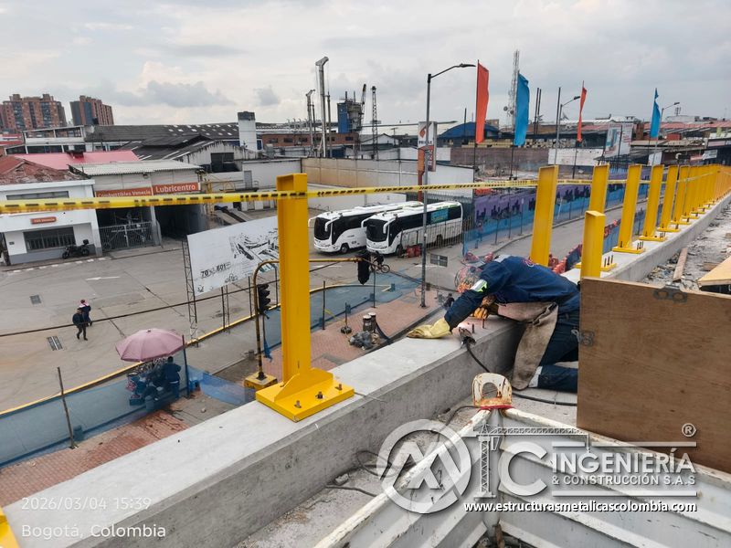 Trabajador instalando baranda amarilla sobre borde de concreto del puente Venecia con fabricación e instalación profesional en Bogotá, Colombia. Montajes, Ingeniería y Construcción. MIC SAS. Trabajador instalando baranda amarilla sobre borde de concreto del puente Venecia en Bogotá, Colombia. Montajes, Ingeniería y Construcción. MIC SAS.