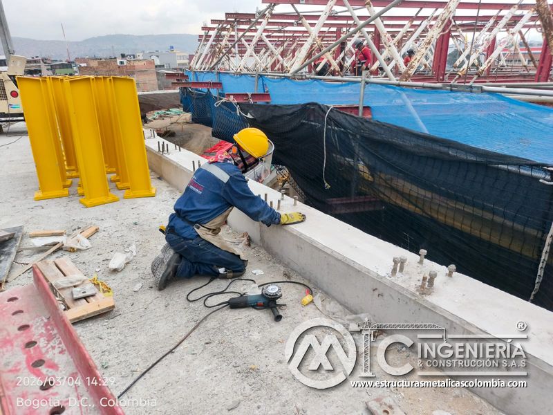 Trabajador perforando o fijando base junto a postes amarillos del puente Venecia con fabricación e instalación profesional en Bogotá, Colombia. Montajes, Ingeniería y Construcción. MIC SAS. Trabajador perforando o fijando base junto a postes amarillos del puente Venecia en Bogotá, Colombia. Montajes, Ingeniería y Construcción. MIC SAS.