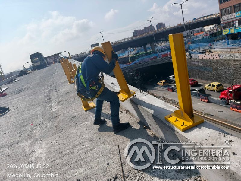 Trabajador perforando o ajustando base de poste amarillo del puente Venecia con fabricación e instalación profesional en Bogotá, Colombia. Montajes, Ingeniería y Construcción. MIC SAS. Trabajador perforando o ajustando base de poste amarillo del puente Venecia en Bogotá, Colombia. Montajes, Ingeniería y Construcción. MIC SAS.