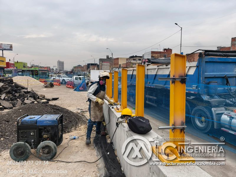 Trabajador junto a poste amarillo y equipo de soldadura del puente Venecia con fabricación e instalación profesional en Bogotá, Colombia. Montajes, Ingeniería y Construcción. MIC SAS. Trabajador junto a poste amarillo y equipo de soldadura del puente Venecia en Bogotá, Colombia. Montajes, Ingeniería y Construcción. MIC SAS.