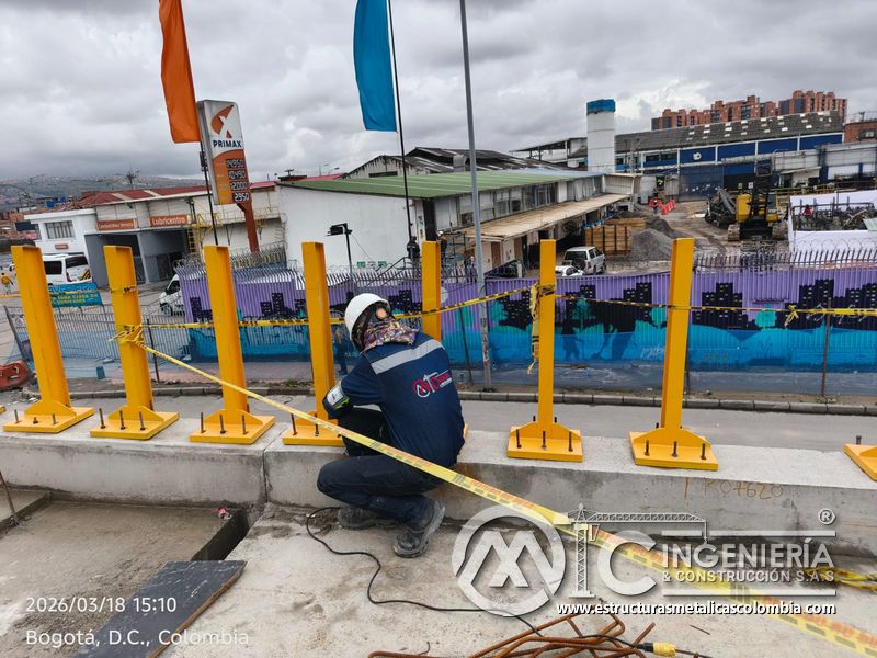 Trabajador fijando base de poste amarillo sobre pretil del puente Venecia con fabricación e instalación profesional en Bogotá, Colombia. Montajes, Ingeniería y Construcción. MIC SAS. Trabajador fijando base de poste amarillo sobre pretil del puente Venecia en Bogotá, Colombia. Montajes, Ingeniería y Construcción. MIC SAS.