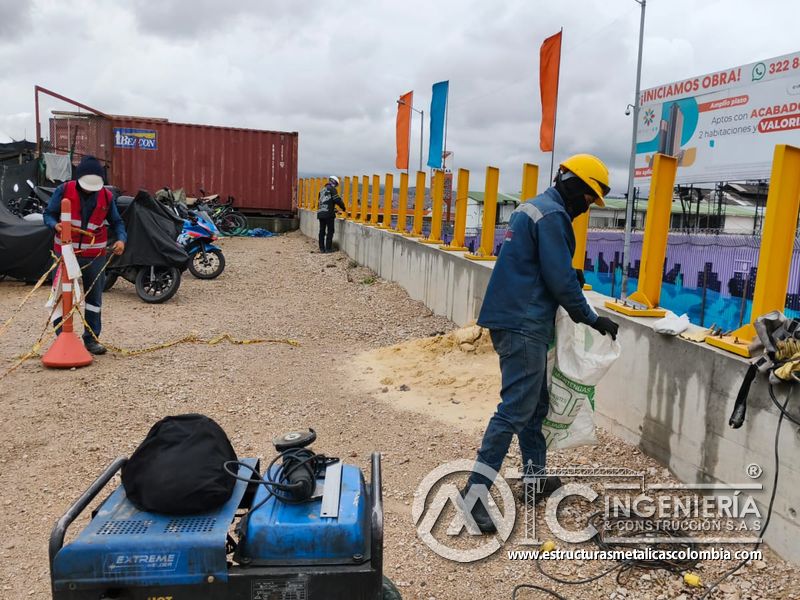 Trabajador junto a postes amarillos y equipo de obra del puente Venecia con fabricación e instalación profesional en Bogotá, Colombia. Montajes, Ingeniería y Construcción. MIC SAS. Trabajador junto a postes amarillos y equipo de obra del puente Venecia en Bogotá, Colombia. Montajes, Ingeniería y Construcción. MIC SAS.