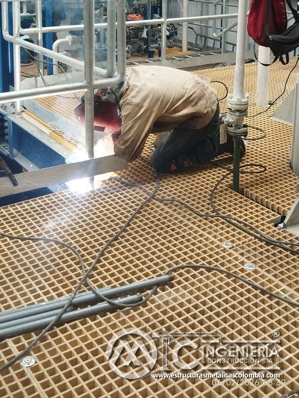 Soldadura sobre piso de rejilla en pasarela industrial del Edificio eléctrico CCM - Brinsa con fabricación e instalación profesional en Bogotá, Colombia. Montajes, Ingeniería y Construcción. MIC SAS. Soldadura sobre piso de rejilla en pasarela industrial del Edificio eléctrico CCM - Brinsa en Bogotá, Colombia. Montajes, Ingeniería y Construcción. MIC SAS.