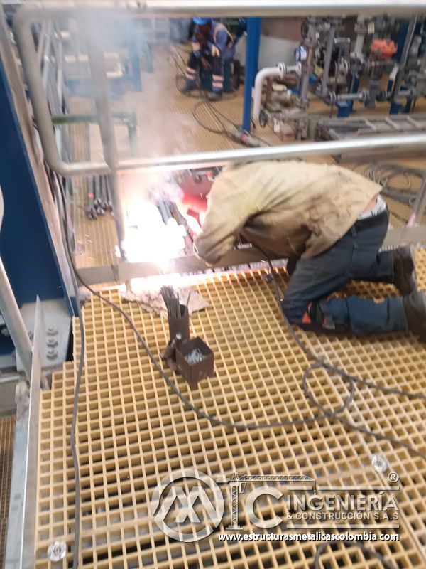 Soldadura sobre piso de rejilla en plataforma metálica del Edificio eléctrico CCM - Brinsa con fabricación e instalación profesional en Bogotá, Colombia. Montajes, Ingeniería y Construcción. MIC SAS. Soldadura sobre piso de rejilla en plataforma metálica del Edificio eléctrico CCM - Brinsa en Bogotá, Colombia. Montajes, Ingeniería y Construcción. MIC SAS.