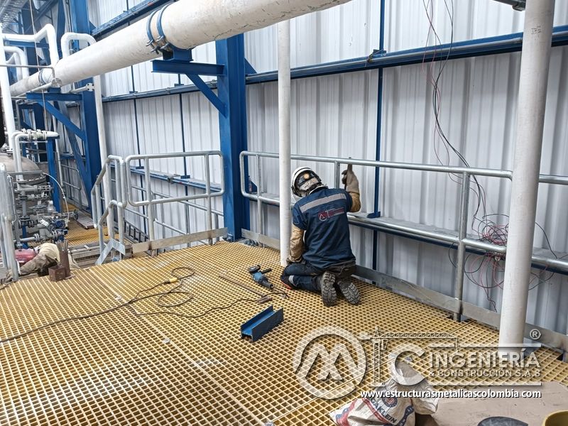 Trabajador sobre piso de rejilla junto a barandas del Edificio eléctrico CCM - Brinsa con fabricación e instalación profesional en Bogotá, Colombia. Montajes, Ingeniería y Construcción. MIC SAS. Trabajador sobre piso de rejilla junto a barandas del Edificio eléctrico CCM - Brinsa en Bogotá, Colombia. Montajes, Ingeniería y Construcción. MIC SAS.