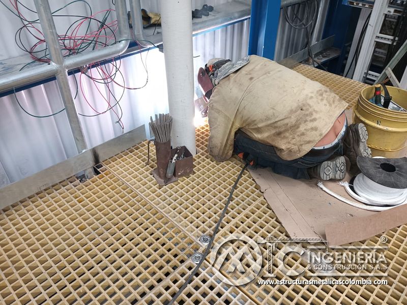Trabajador soldando en piso de rejilla y plataforma del Edificio eléctrico CCM - Brinsa con fabricación e instalación profesional en Bogotá, Colombia. Montajes, Ingeniería y Construcción. MIC SAS. Trabajador soldando en piso de rejilla y plataforma del Edificio eléctrico CCM - Brinsa en Bogotá, Colombia. Montajes, Ingeniería y Construcción. MIC SAS.