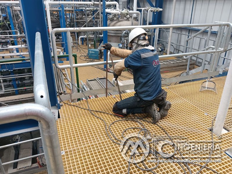 Trabajador ajustando piso de rejilla junto a baranda del Edificio eléctrico CCM - Brinsa con fabricación e instalación profesional en Bogotá, Colombia. Montajes, Ingeniería y Construcción. MIC SAS. Trabajador ajustando piso de rejilla junto a baranda del Edificio eléctrico CCM - Brinsa en Bogotá, Colombia. Montajes, Ingeniería y Construcción. MIC SAS.