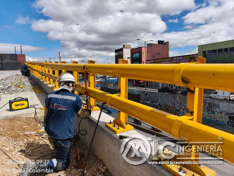 Trabajadores ajustando pasamanos tubular amarillo en baranda del puente Venecia con fabricación e instalación profesional en Bogotá, Colombia. Montajes, Ingeniería y Construcción. MIC SAS. Trabajadores ajustando pasamanos tubular amarillo en baranda del puente Venecia en Bogotá, Colombia. Montajes, Ingeniería y Construcción. MIC SAS.