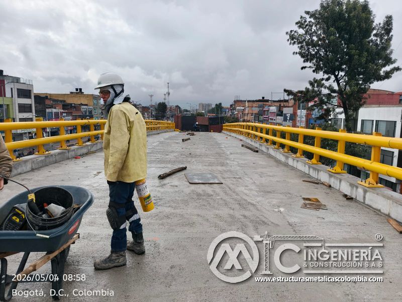 Trabajador revisando barandas amarillas sobre losa del puente del puente Venecia con fabricación e instalación profesional en Bogotá, Colombia. Montajes, Ingeniería y Construcción. MIC SAS. Trabajador revisando barandas amarillas sobre losa del puente del puente Venecia en Bogotá, Colombia. Montajes, Ingeniería y Construcción. MIC SAS.