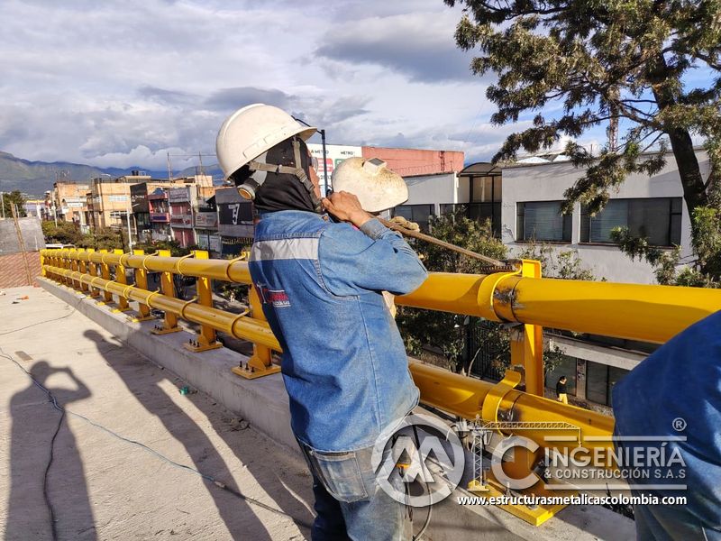 Trabajador verificando pasamanos tubular amarillo del puente Venecia con fabricación e instalación profesional en Bogotá, Colombia. Montajes, Ingeniería y Construcción. MIC SAS. Trabajador verificando pasamanos tubular amarillo del puente Venecia en Bogotá, Colombia. Montajes, Ingeniería y Construcción. MIC SAS.