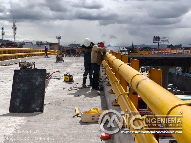 Trabajadores instalando pasamanos tubular amarillo del puente Venecia con fabricación e instalación profesional en Bogotá, Colombia. Montajes, Ingeniería y Construcción. MIC SAS. Trabajadores instalando pasamanos tubular amarillo del puente Venecia en Bogotá, Colombia. Montajes, Ingeniería y Construcción. MIC SAS.