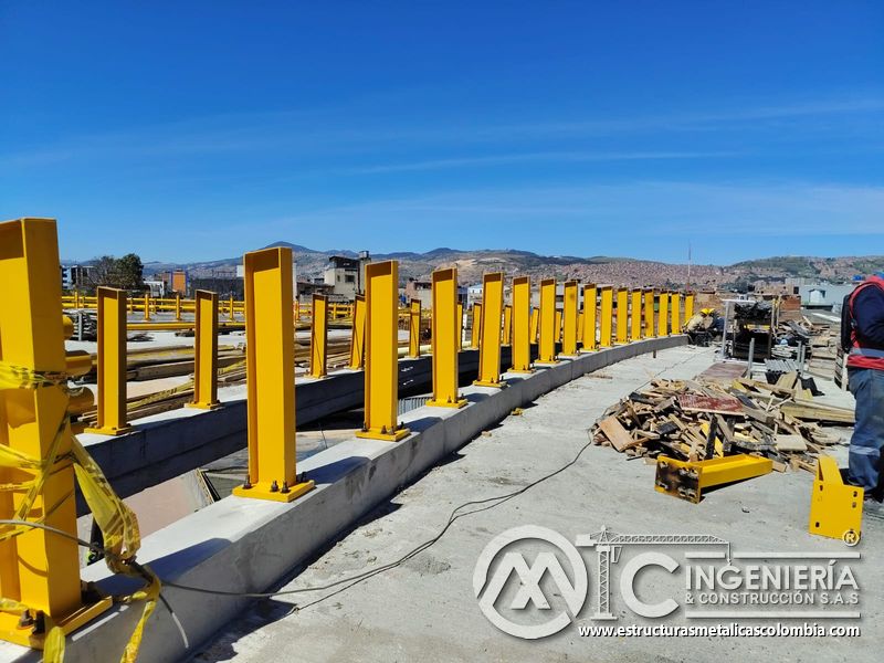 Contemple la hilera de postes amarillos anclados al parapeto como base de la próxima defensa del puente en Bogotá, Colombia. Montajes, Ingeniería y Construcción. MIC SAS.