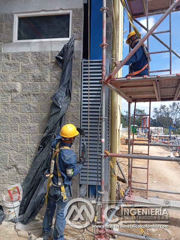 Persiana de ventilación con trabajador en acceso exterior del Edificio eléctrico CCM - Brinsa en Bogotá, Colombia. Montajes, Ingeniería y Construcción. MIC SAS.