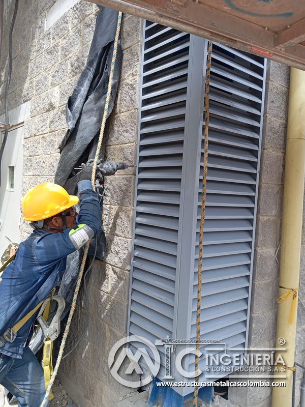 Persiana vertical de ventilación con trabajador en fachada del Edificio eléctrico CCM - Brinsa en Bogotá, Colombia. Montajes, Ingeniería y Construcción. MIC SAS.