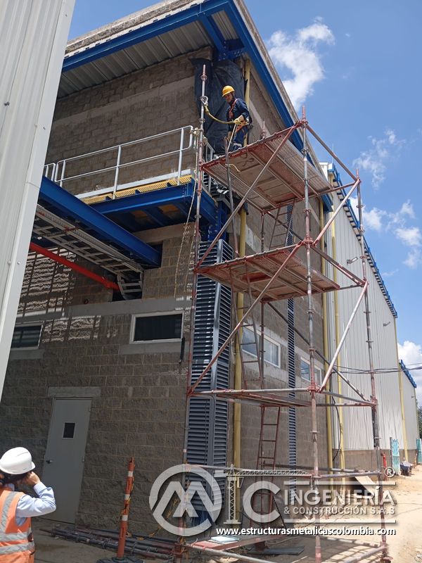 Persiana vertical de ventilación con trabajador en fachada del Edificio eléctrico CCM - Brinsa en Bogotá, Colombia. Montajes, Ingeniería y Construcción. MIC SAS.