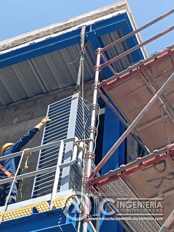 Trabajador ajustando baranda junto a persiana y andamio del Edificio eléctrico CCM - Brinsa en Bogotá, Colombia. Montajes, Ingeniería y Construcción. MIC SAS.
