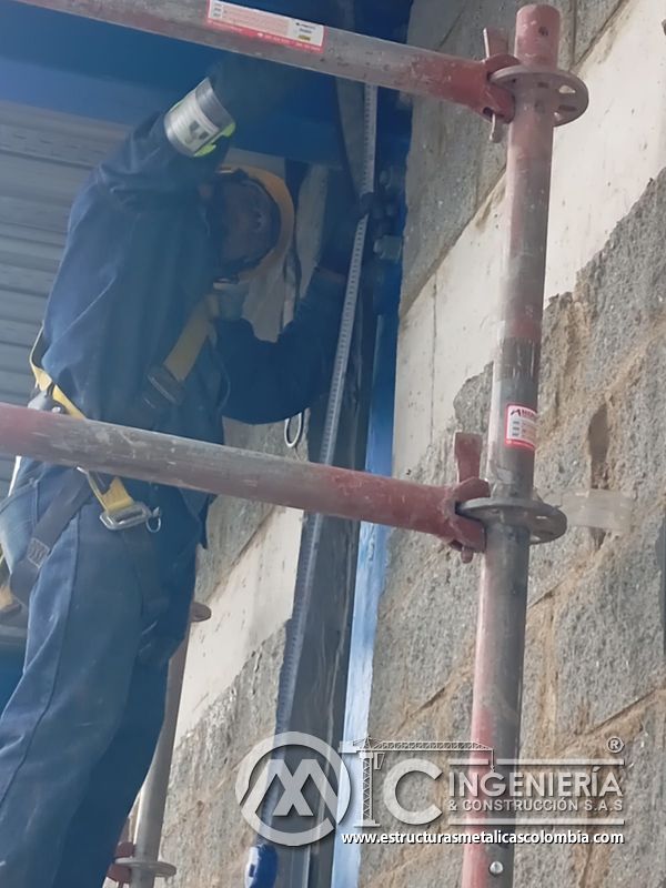 Trabajador en andamio instalando persiana metálica vertical del Edificio eléctrico CCM - Brinsa en Bogotá, Colombia. Montajes, Ingeniería y Construcción. MIC SAS.