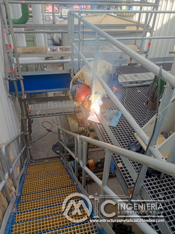 Trabajador soldando piso de rejilla en plataforma del Edificio eléctrico CCM - Brinsa en Bogotá, Colombia. Montajes, Ingeniería y Construcción. MIC SAS.