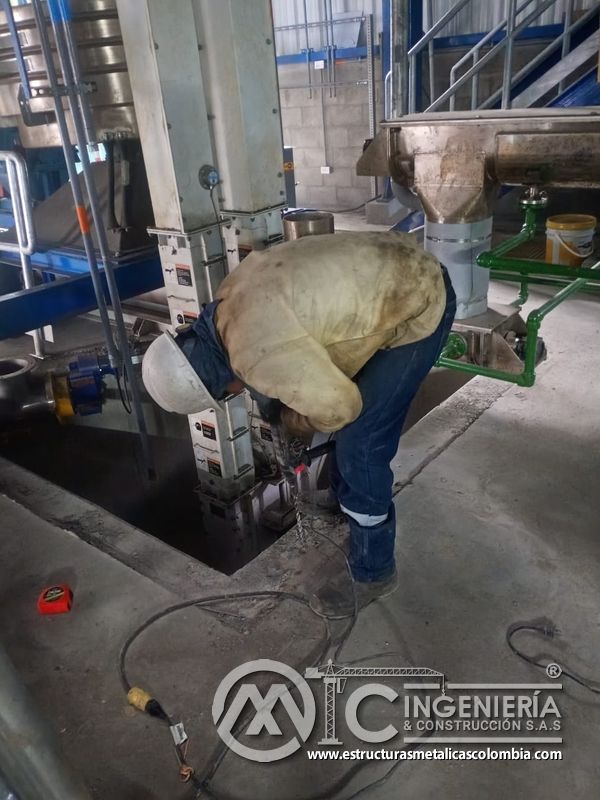 Trabajador ajustando baranda junto a piso de rejilla del Edificio eléctrico CCM - Brinsa en Bogotá, Colombia. Montajes, Ingeniería y Construcción. MIC SAS.