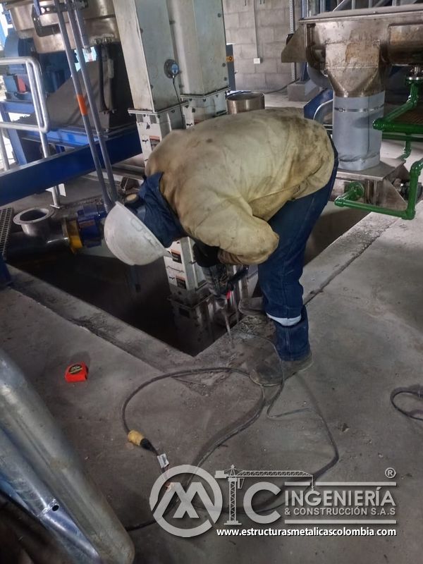 Trabajador soldando o ajustando baranda en plataforma del Edificio eléctrico CCM - Brinsa en Bogotá, Colombia. Montajes, Ingeniería y Construcción. MIC SAS.