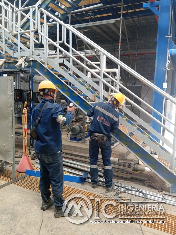 Trabajador ajustando baranda junto a escalera y piso de rejilla del Edificio eléctrico CCM - Brinsa en Bogotá, Colombia. Montajes, Ingeniería y Construcción. MIC SAS.