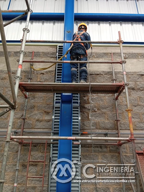 Trabajador en plataforma instalando persiana metálica vertical del Edificio eléctrico CCM - Brinsa en Bogotá, Colombia. Montajes, Ingeniería y Construcción. MIC SAS.