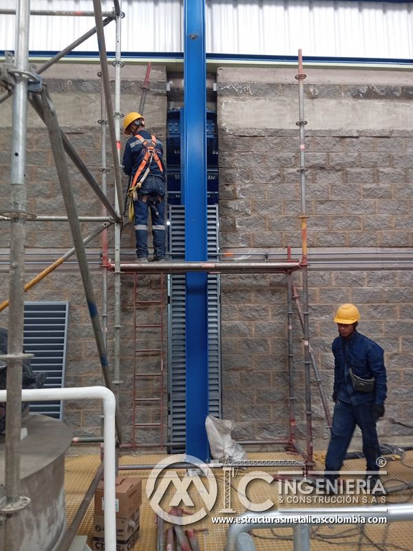 Fachada con persiana vertical y trabajador en montaje exterior del Edificio eléctrico CCM - Brinsa en Bogotá, Colombia. Montajes, Ingeniería y Construcción. MIC SAS.