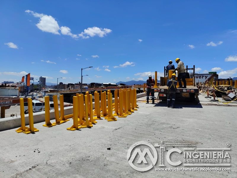 Conozca cómo descargamos postes metálicos amarillos para reforzar la protección lateral del puente vial en Bogotá, Colombia. Montajes, Ingeniería y Construcción. MIC SAS.