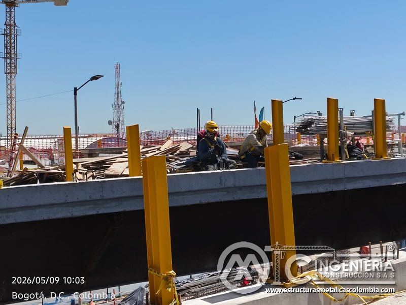 Acompañe la cuadrilla ensamblando columnas amarillas sobre el tablero vial elevado del puente vehicular en Bogotá, Colombia. Montajes, Ingeniería y Construcción. MIC SAS.