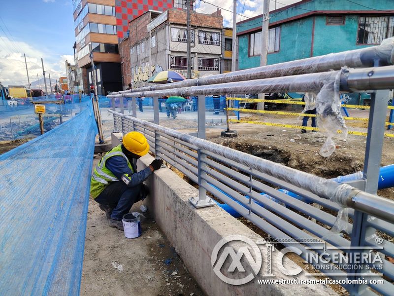 Conserve la baranda peatonal con pintura gris aplicada en bases y travesaños durante la fase de acabado en Bogotá, Colombia. Montajes, Ingeniería y Construcción. MIC SAS.