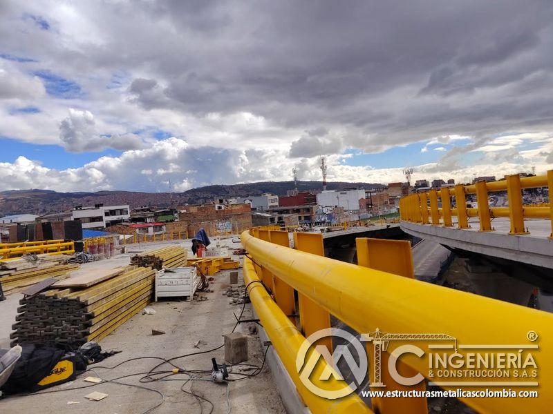 Recorra la curva del acceso protegida con baranda tubular adaptada al trazado del puente con precisión, en Bogotá, Colombia. Montajes, Ingeniería y Construcción. MIC SAS.