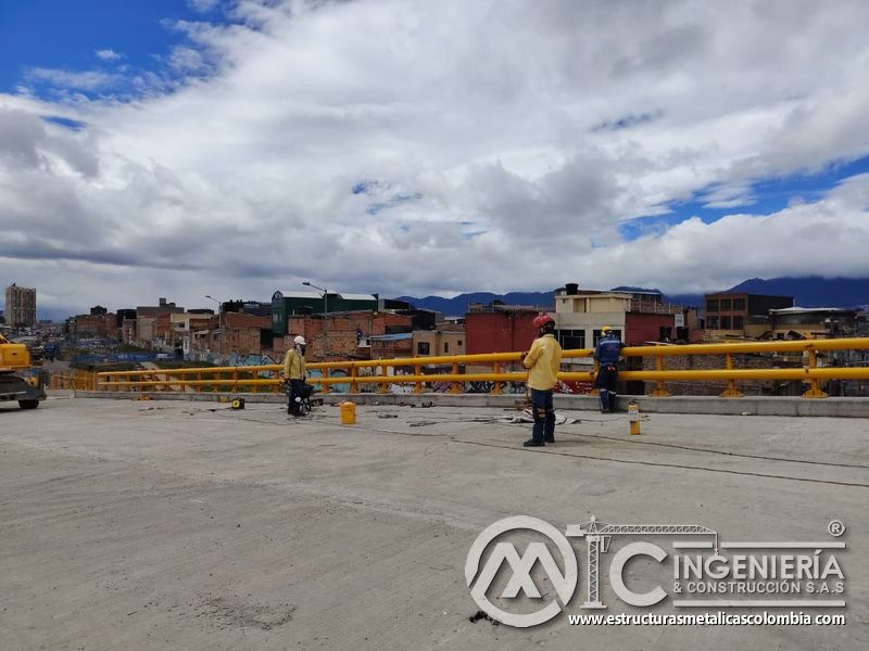 Documente la inspección final de la baranda amarilla continua sobre el borde curvo del puente con rigor en Bogotá, Colombia. Montajes, Ingeniería y Construcción. MIC SAS.