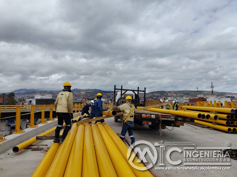Coordine la recepción de tubos amarillos con una cuadrilla preparada para abastecer barandas del puente en Bogotá, Colombia. Montajes, Ingeniería y Construcción. MIC SAS.