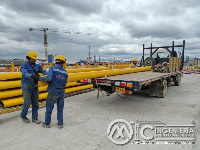 Compruebe la descarga precisa de tubería amarilla de acero para sostener la infraestructura vial urbana en Bogotá, Colombia. Montajes, Ingeniería y Construcción. MIC SAS.